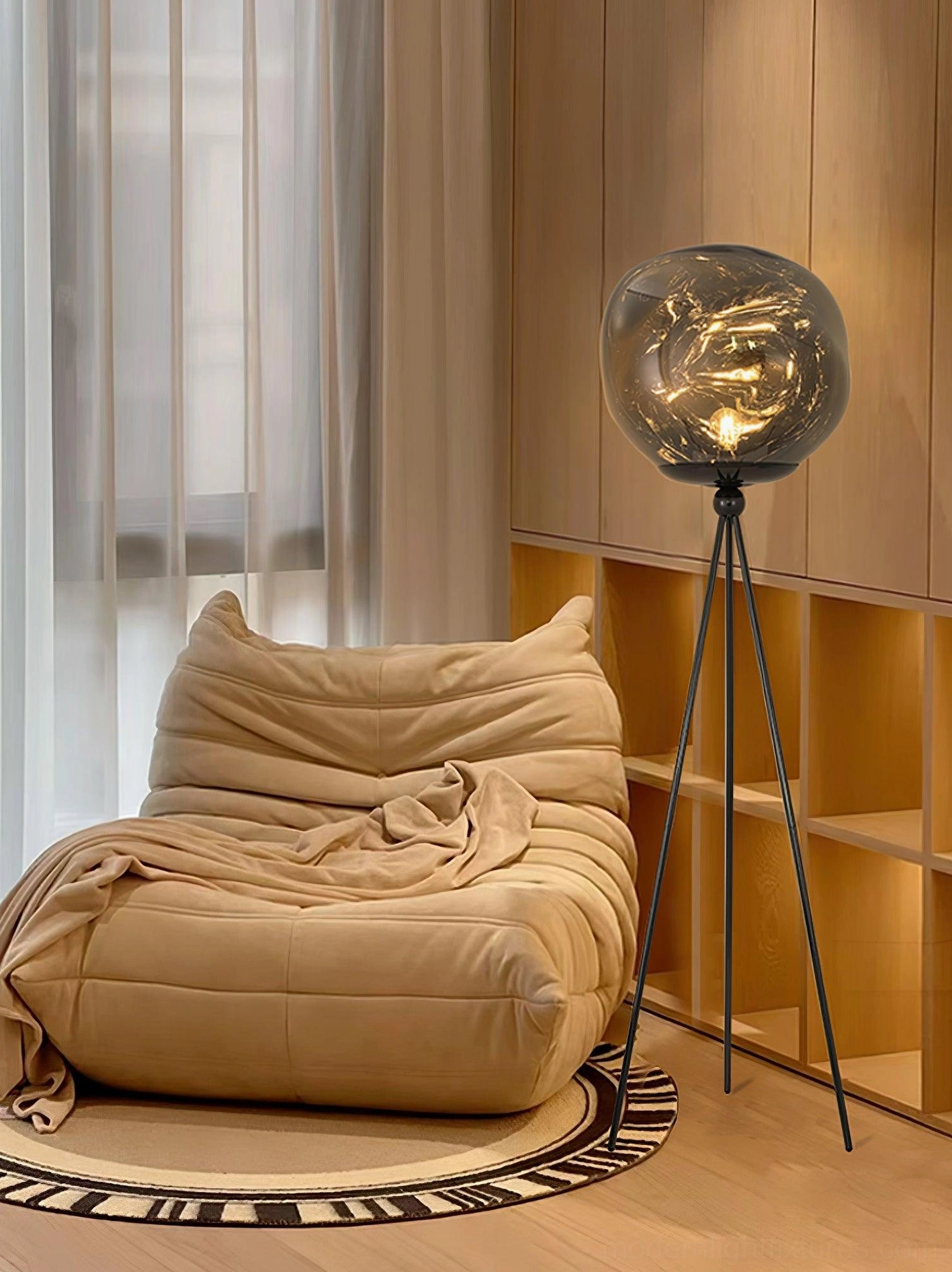 Contemporary tripod floor lamp with artistic molten lava glass shade and black metal tripod frame detail view