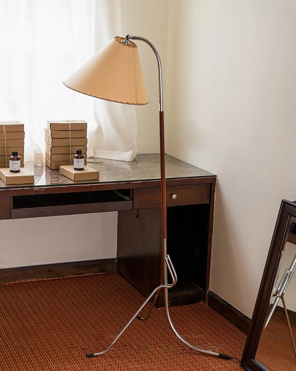 Tripod floor lamp in home desk station setting with decorative wooden boxes and aroma bottles, side rear view showing complete fixture from behind