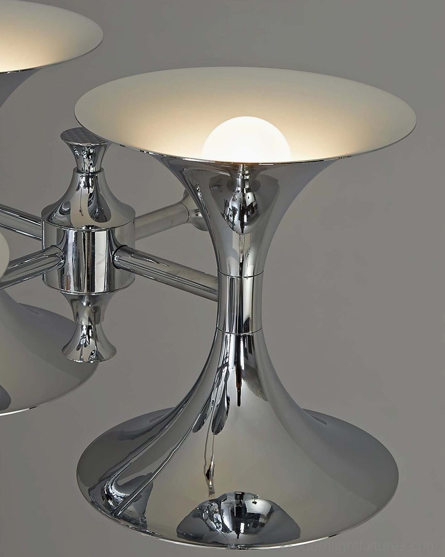 Tromelle chrome chandelier installed in elegant modern dining setting with architectural lighting