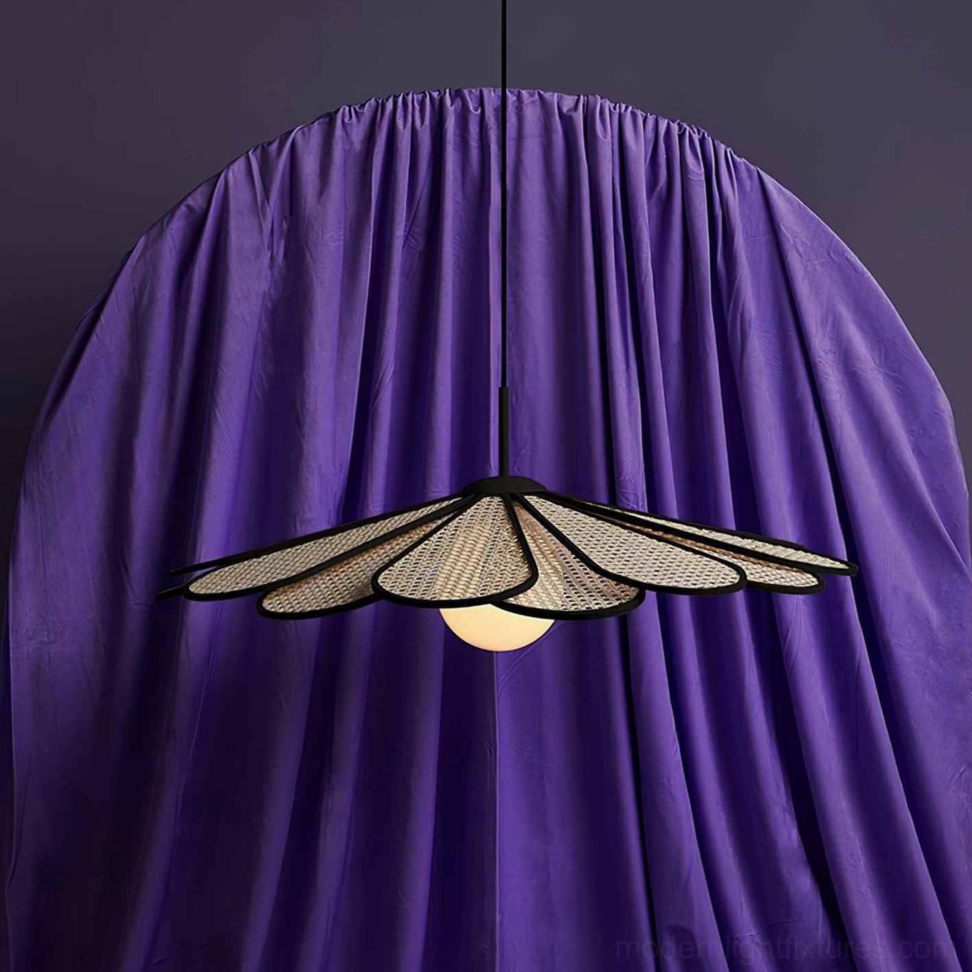 Modern rattan pendant lamp with black trim shown from front angle against purple studio backdrop