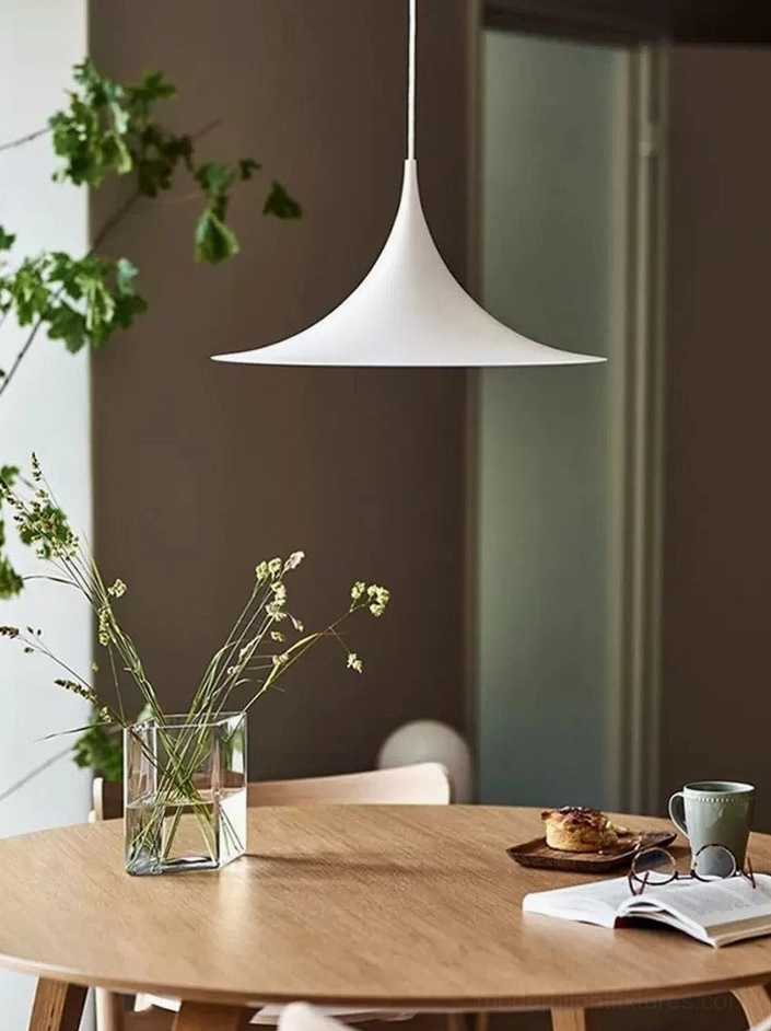 White trumpet pendant light in Nordic minimalist dining room with round wooden table