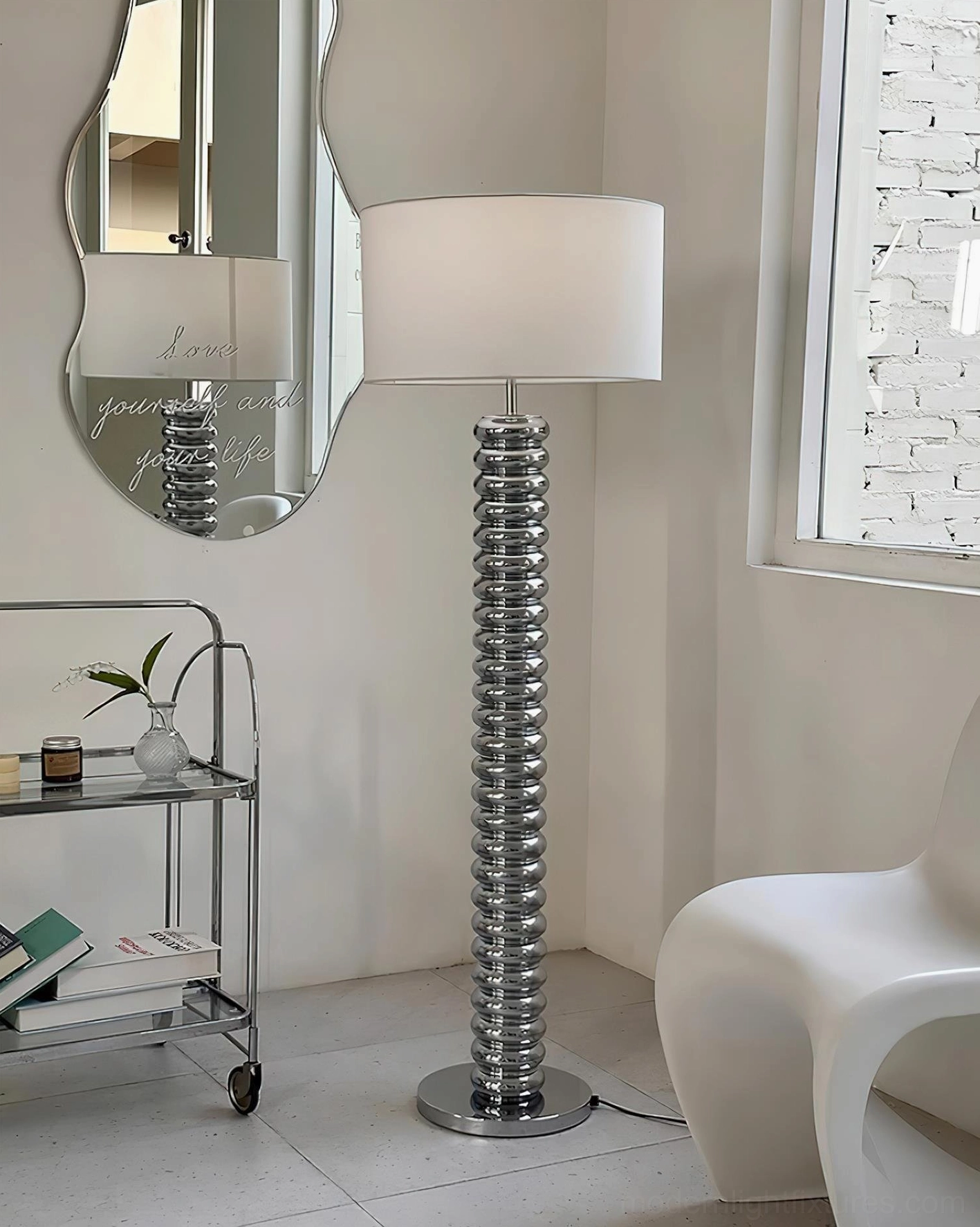 Silver chrome Tula Twist floor lamp with ribbed pole design in contemporary living room with geometric mirror accent