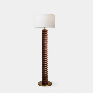 Tula Twist modern floor lamp with dark walnut ribbed wood pole and brass base, featuring white fabric drum shade, studio front view