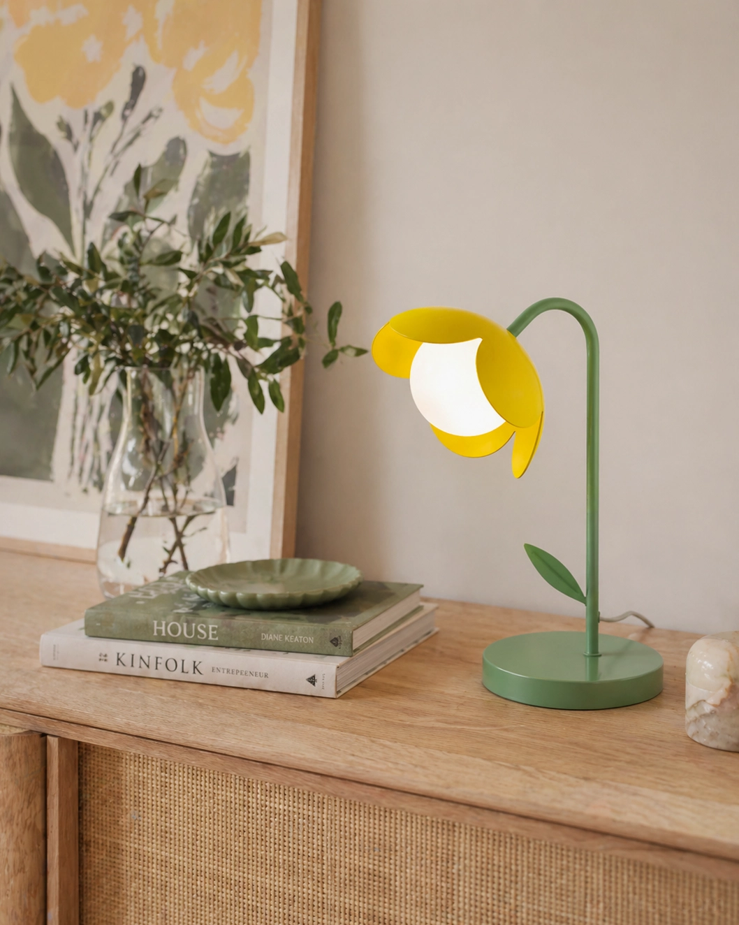 Yellow tulip table lamp on wooden sideboard with potted plant and art books - contemporary decorative table light