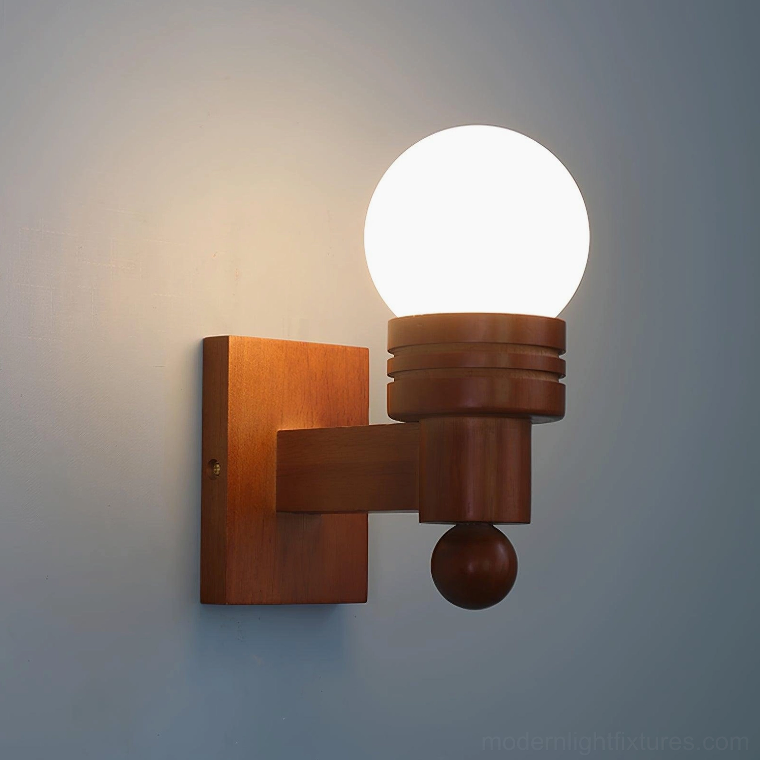 Tupelo modern wall lamp illuminated with warm ambient lighting against blue wall, showcasing light diffusion and retro design