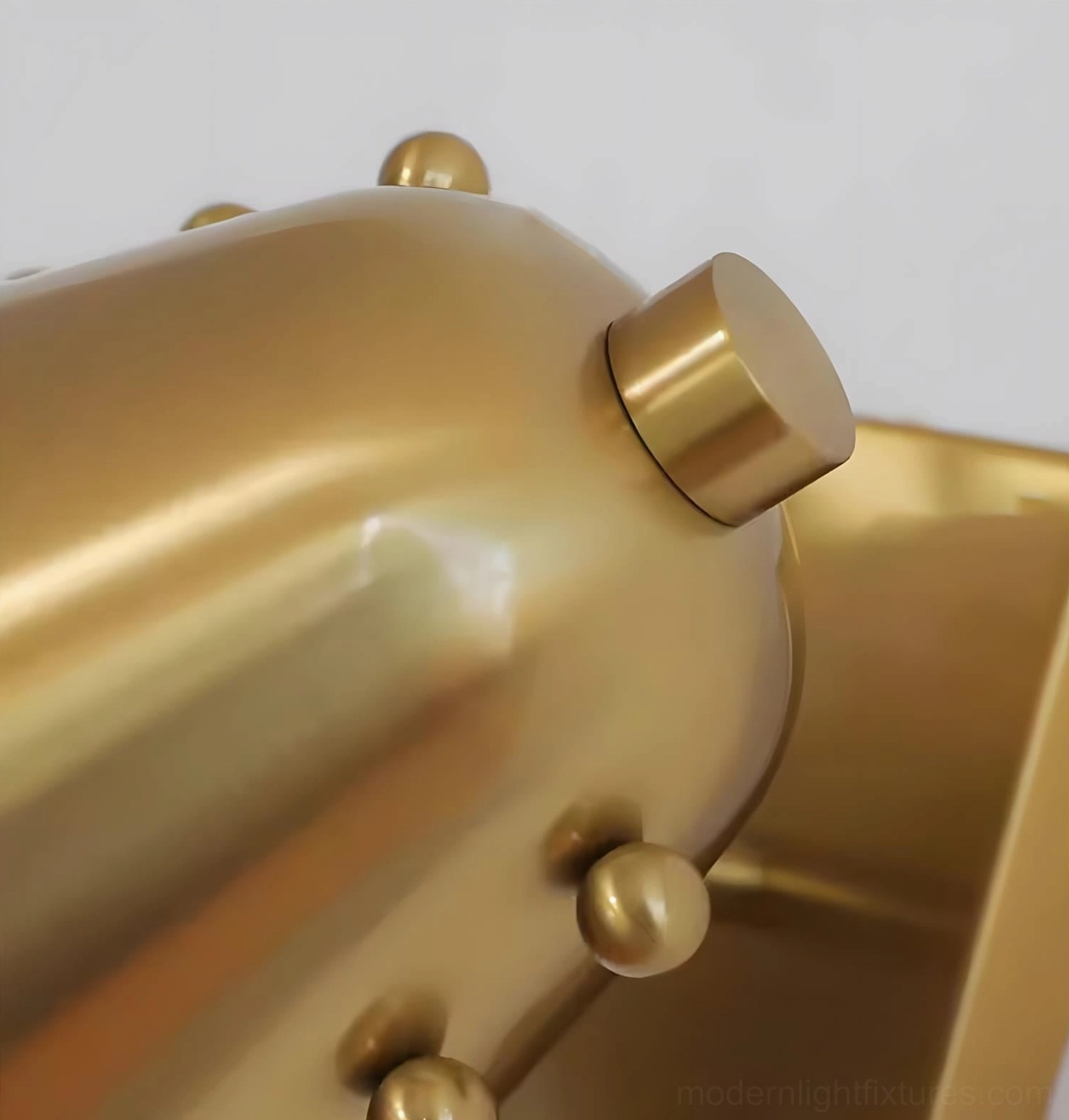 Twilight brass pin wall sconce macro detail shot, polished metal texture and round stud hardware close-up