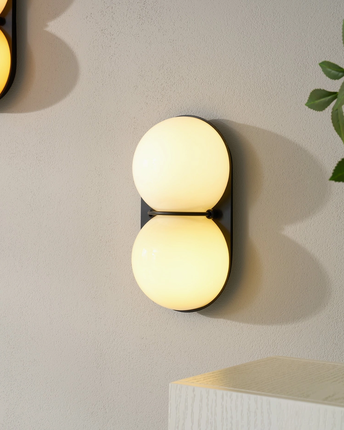 Twinwave double sphere wall light sconce in minimalist modern interior with ambient glow