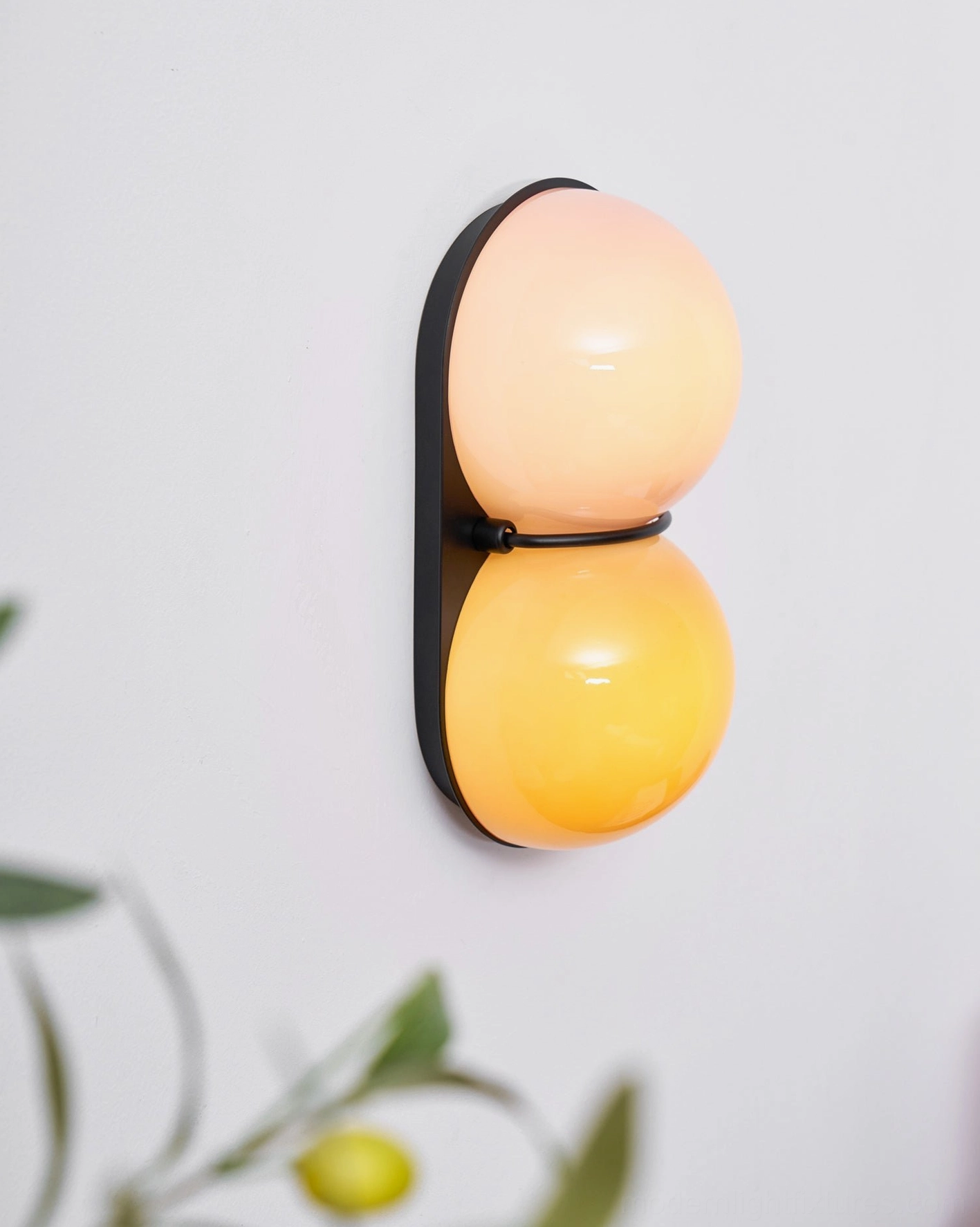 Twinwave wall light sconce design showcasing stacked spheres and curved architectural metal support