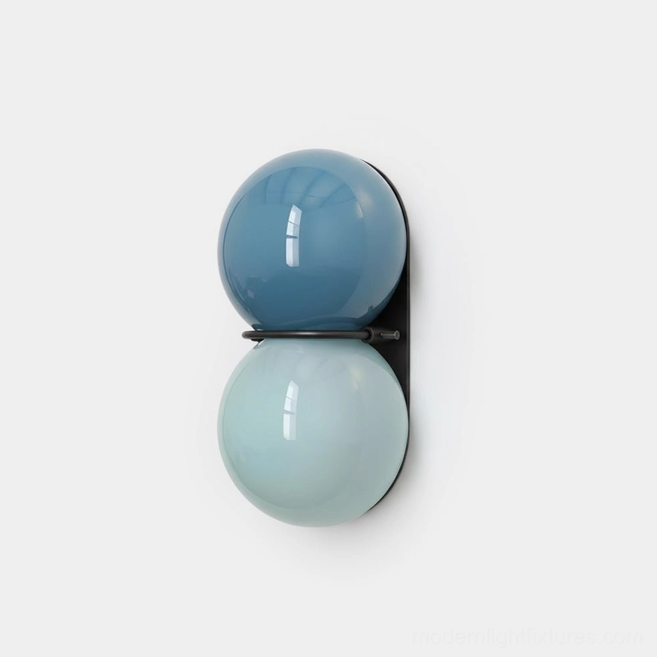 Twinwave double globe wall sconce close-up with gradient blue glass orbs and black metal frame on white background