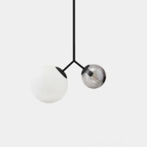 Twis modern dual globe pendant lamp with frosted white and smoke gray glass shades on brass metal frame, front overhead studio view