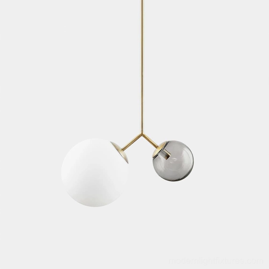 Twis modern pendant lamp variant with brass frame and smoke gray frosted glass globes in contemporary home setting