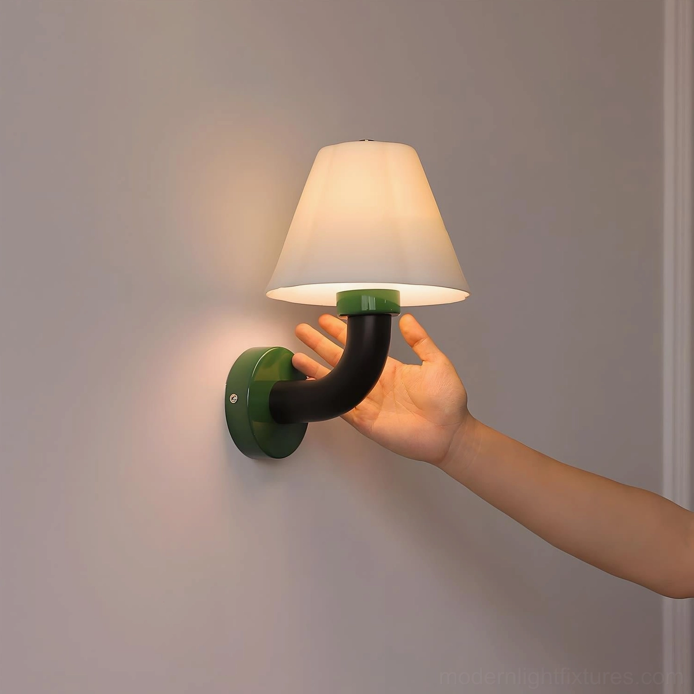 Twist Shine wall sconce with green base and black curved arm in side close-up detail shot showing craftsmanship