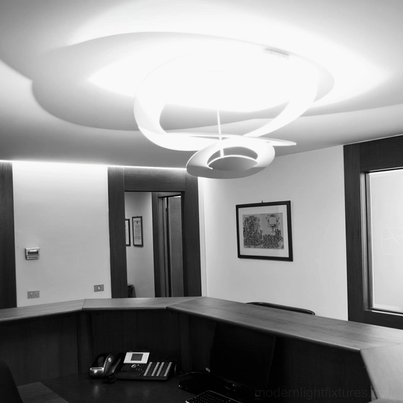 Twisted ring pendant light installation in contemporary office space, cool white productivity lighting