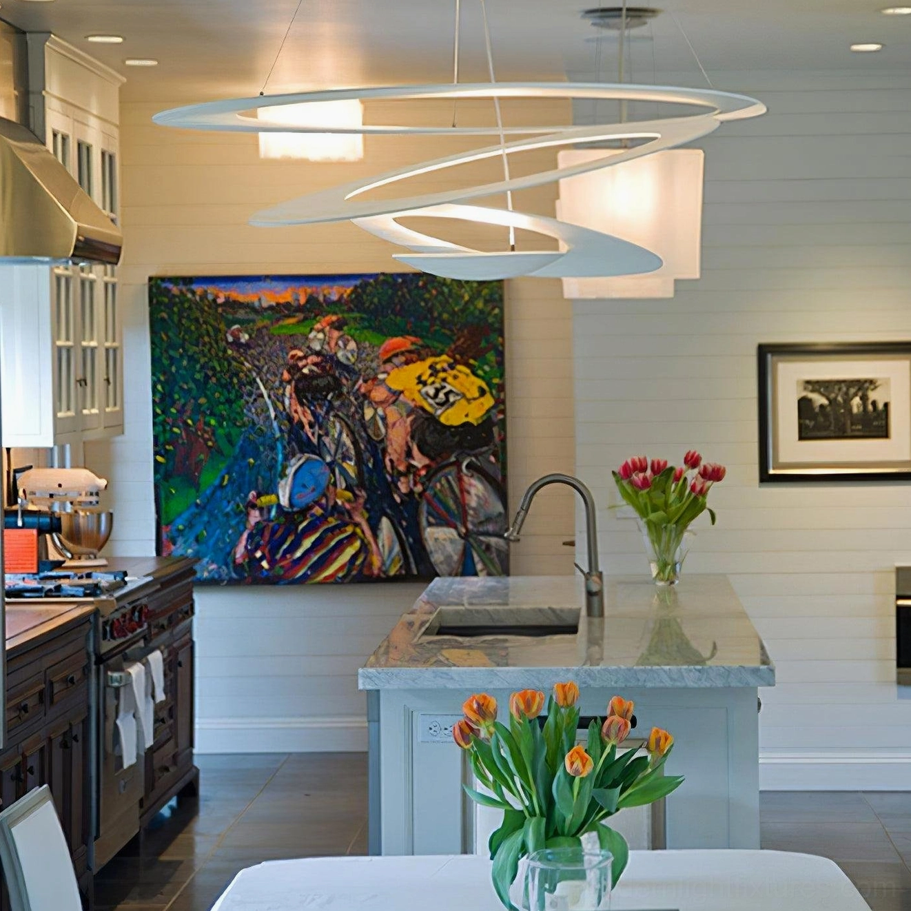 Twisted ring pendant chandelier over kitchen island, light silver layered spiral structure with warm task lighting