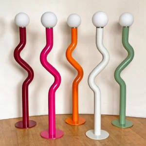 Collection of Twistie floor lamps in multiple color variants showing green, white, black, orange, purple, and caramel finishes with serpentine poles