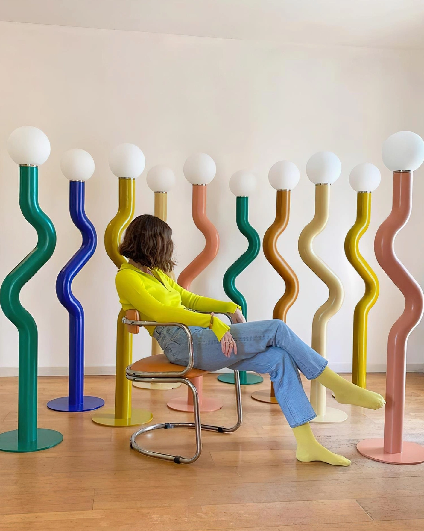 Twistie floor lamps in sunny living area with person seated nearby showing scale of sculptural twisted design