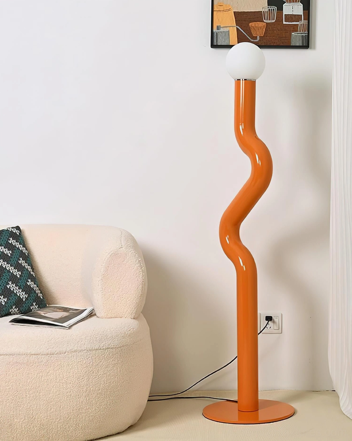 Bright orange Twistie floor lamp beside fabric sofa in cozy living room with visible power cord