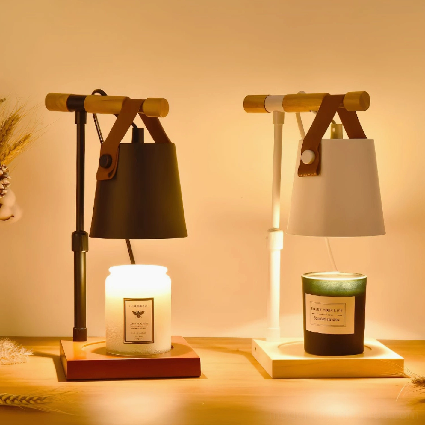 Dual candle warmer lamps in black and white finishes with wooden bases, lit candles on wooden tabletop at night