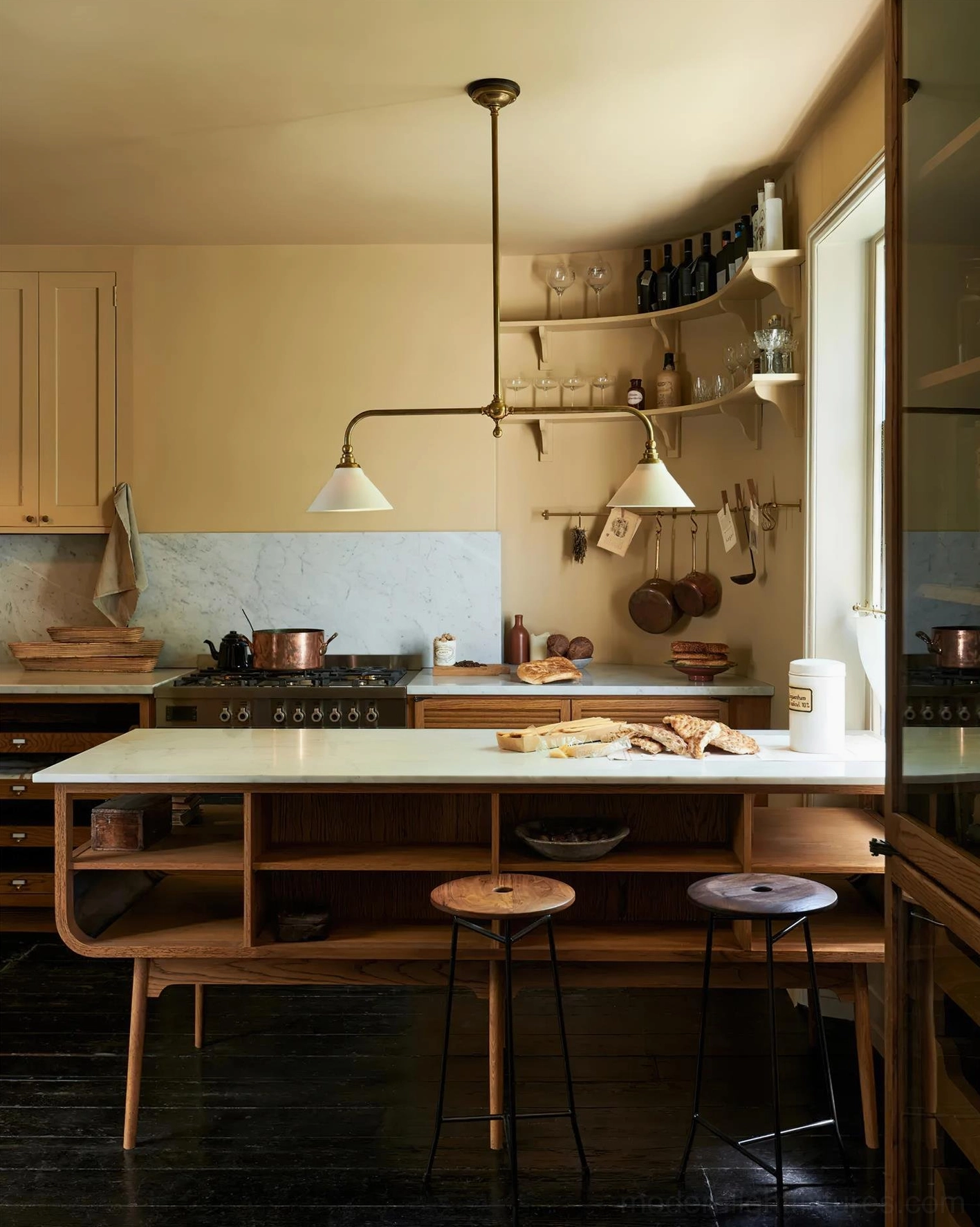 Two-light brass linear pendant fixture with opal ceramic shades installed in contemporary kitchen dining space