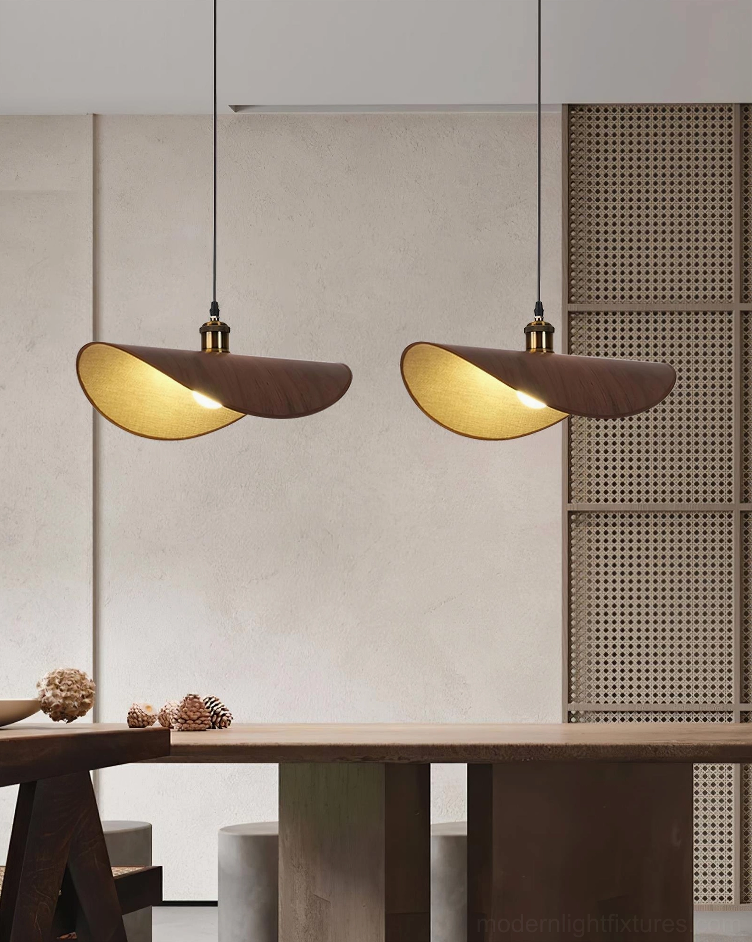 Pair of dark wood wabi-sabi pendant lamps with warm lighting above minimalist dining workspace with woven wall panel