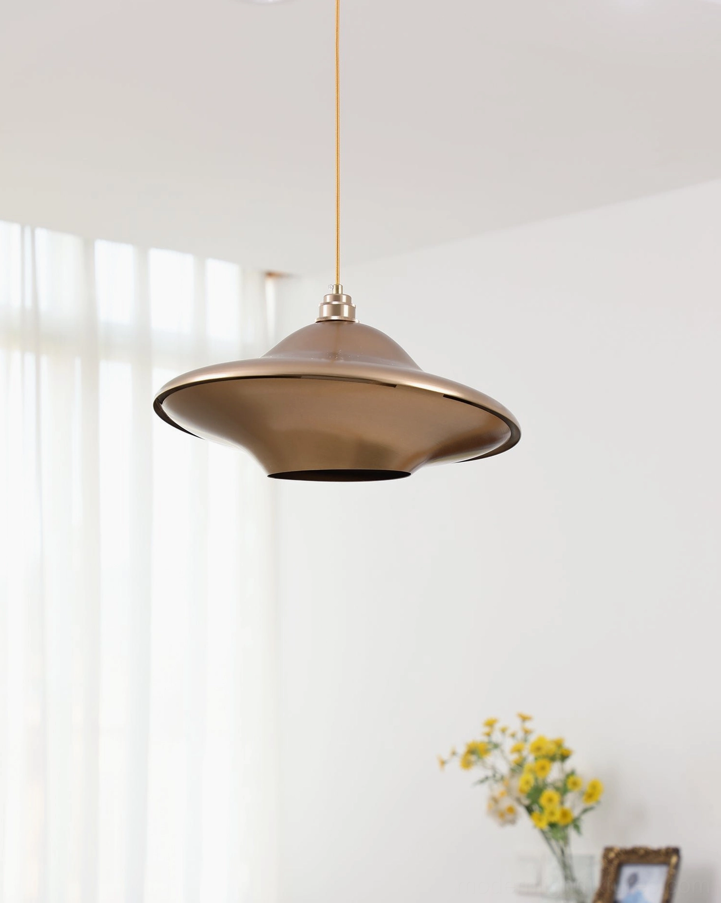 UFO pendant lamp illuminated front view - metal shade with soft interior glow for ambient and task lighting