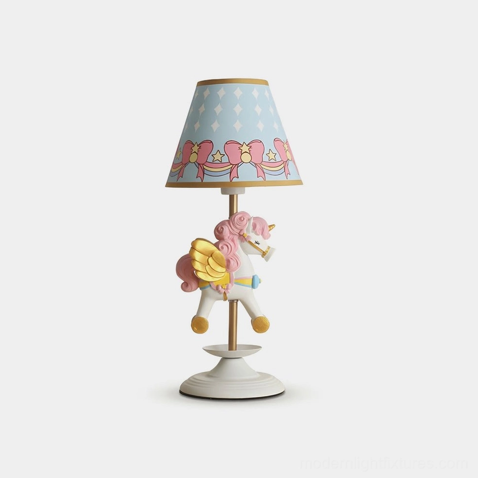 Unicorn carousel table lamp with pastel pink and gold accents, front studio view on white background