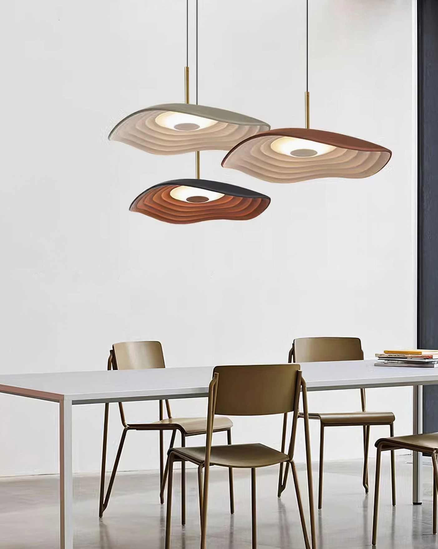 Multiple Valentina wavy pendant fixtures mounted in contemporary dining area with varied color tones and brass suspension