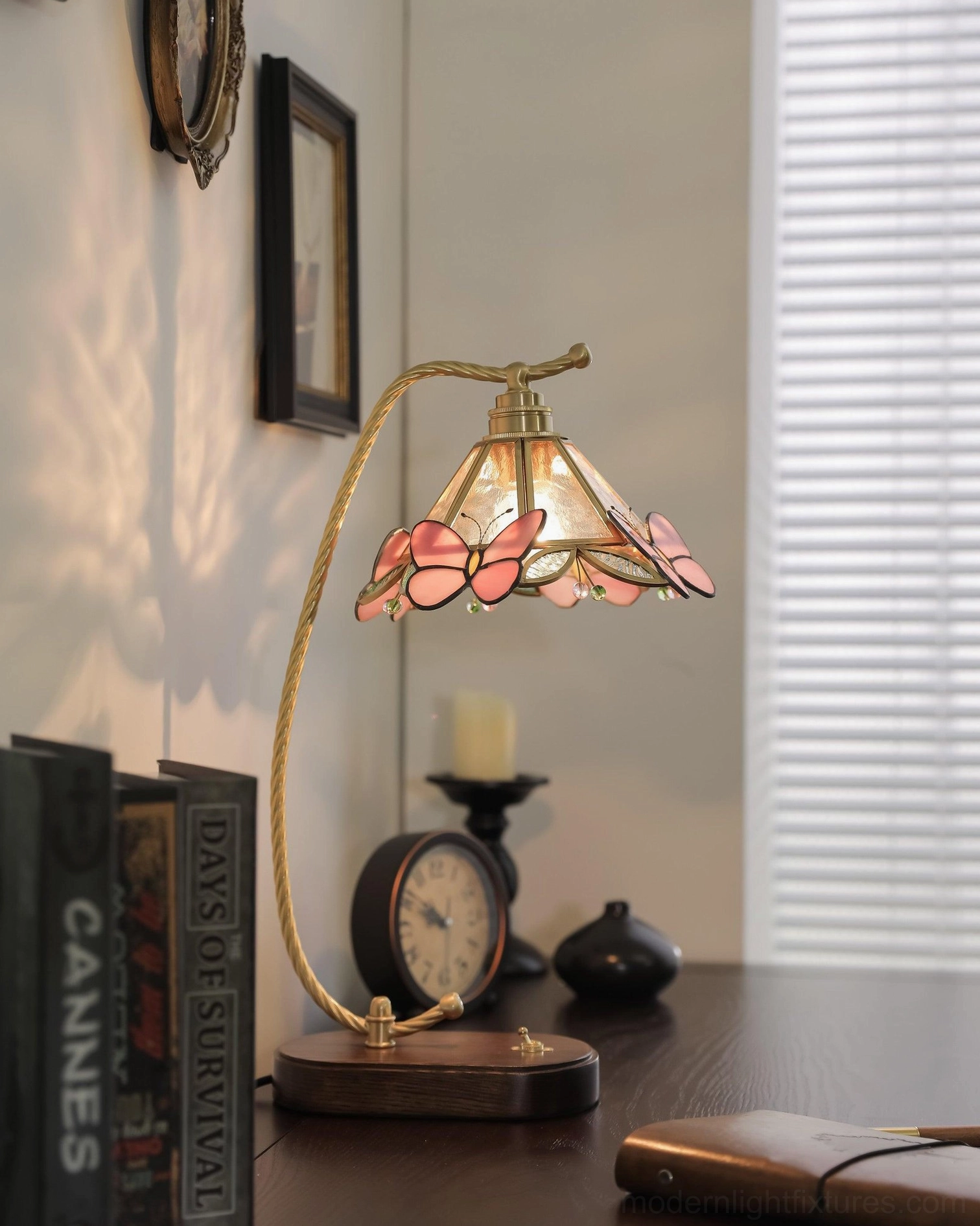 Side view of vintage Valerie Butterfly table lamp on retro study desk with books and decorative items, warm ambient lighting
