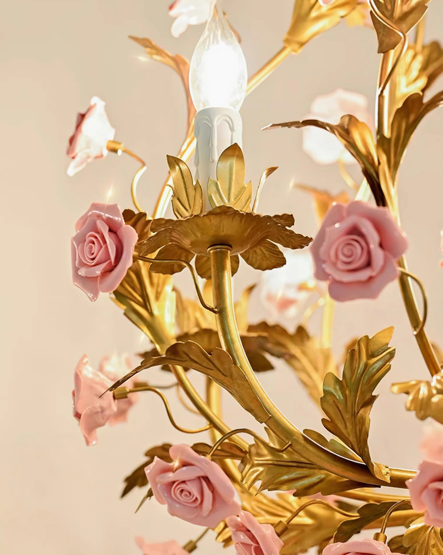 Valrosa botanical chandelier with intricate metal leaf framework adorned with hand-molded ceramic pink roses