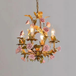 Close-up detail of Valrosa botanical chandelier with hand-molded pink roses and warm gold metal frame against gray wall