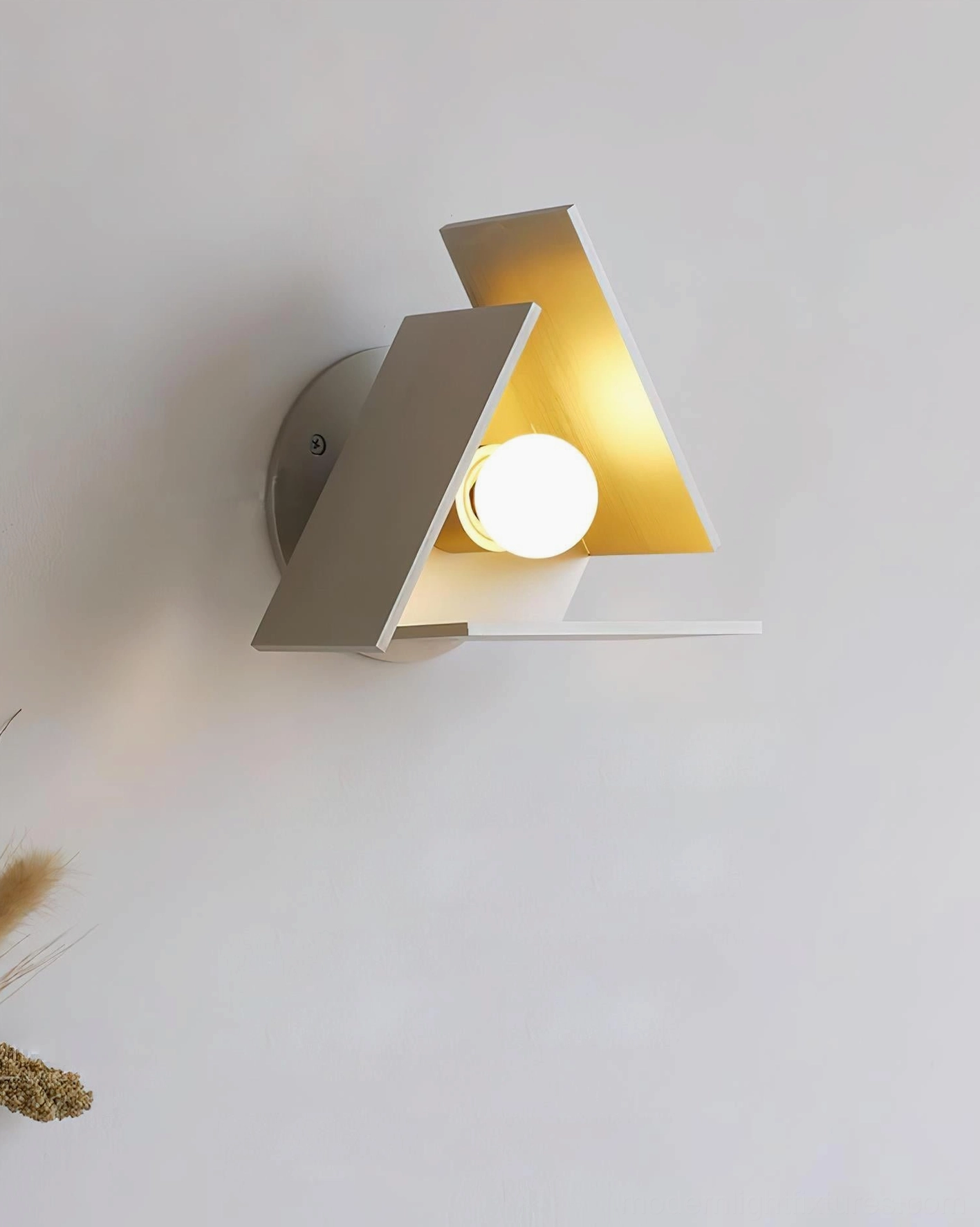 Vanta modern wall sconce right three-quarter angle illuminated with warm light showing matte taupe and gold tone finish