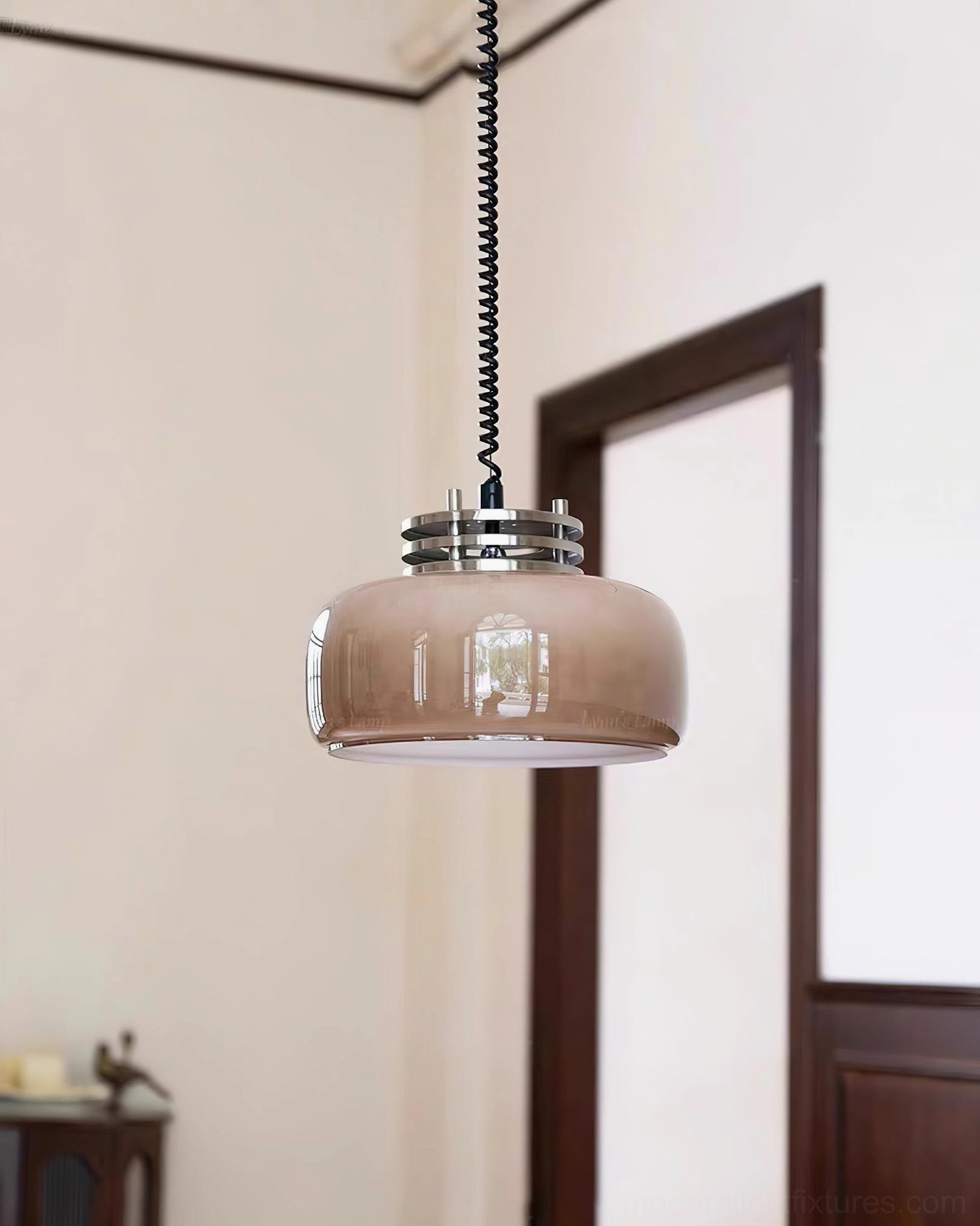Vela glass drum pendant light in home entryway with dark wood door frame, side three-quarter view