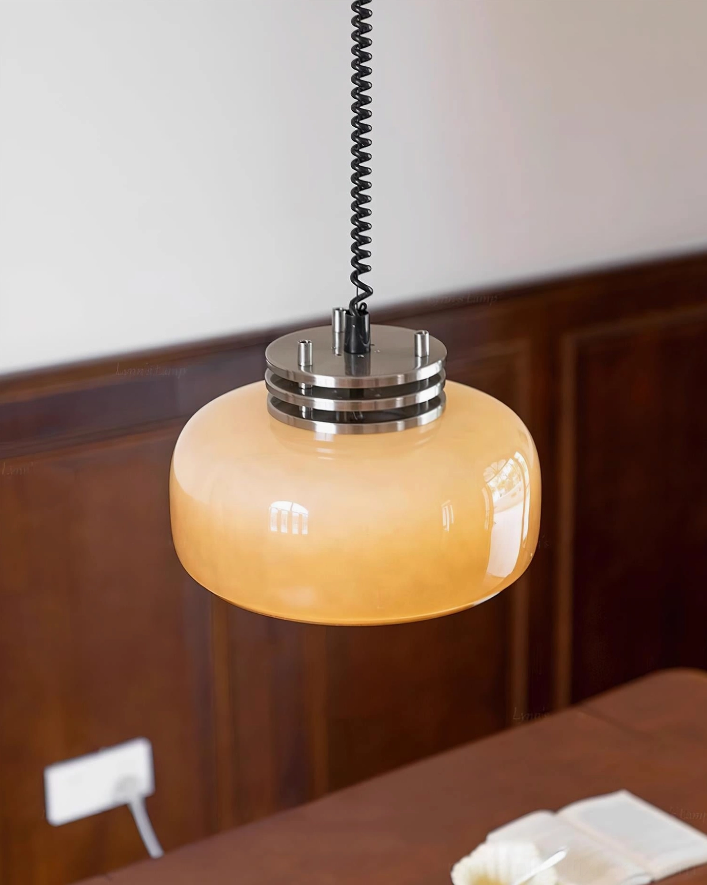 Vela pendant light close-up of translucent taupe brown glass shade with metal hardware accent