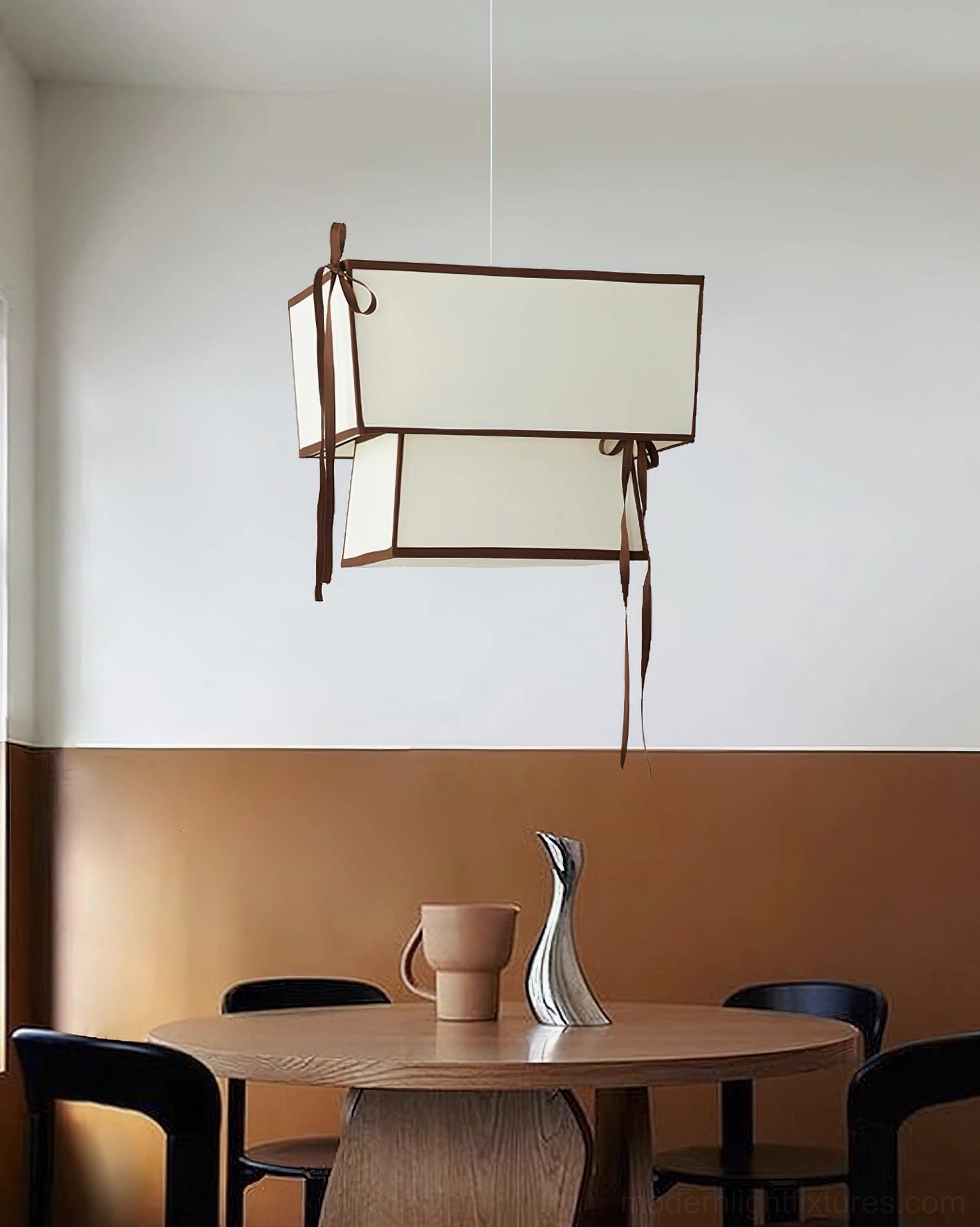 Velina pendant light hanging above modern wooden dining table with warm neutral styling