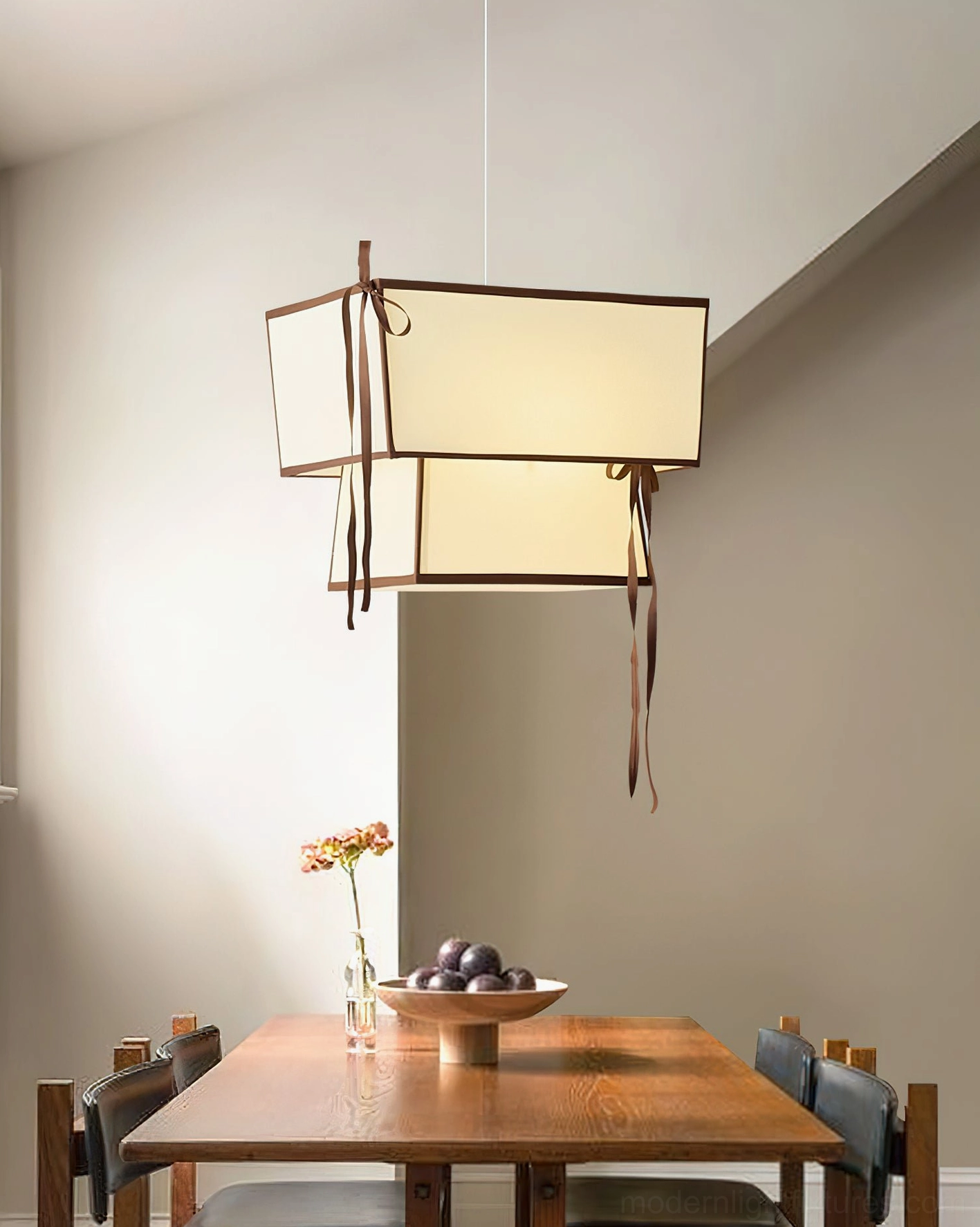 Illuminated Velina two-tier pendant light overhead view in warm dining room ambiance
