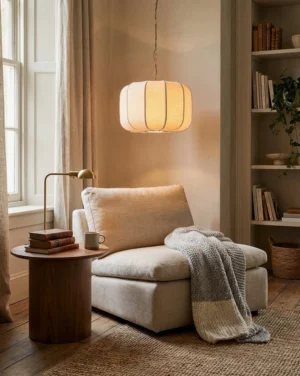 Velune fabric pendant light hanging in modern living room, warm ambient glow through soft fabric shade, brass chain, interior design