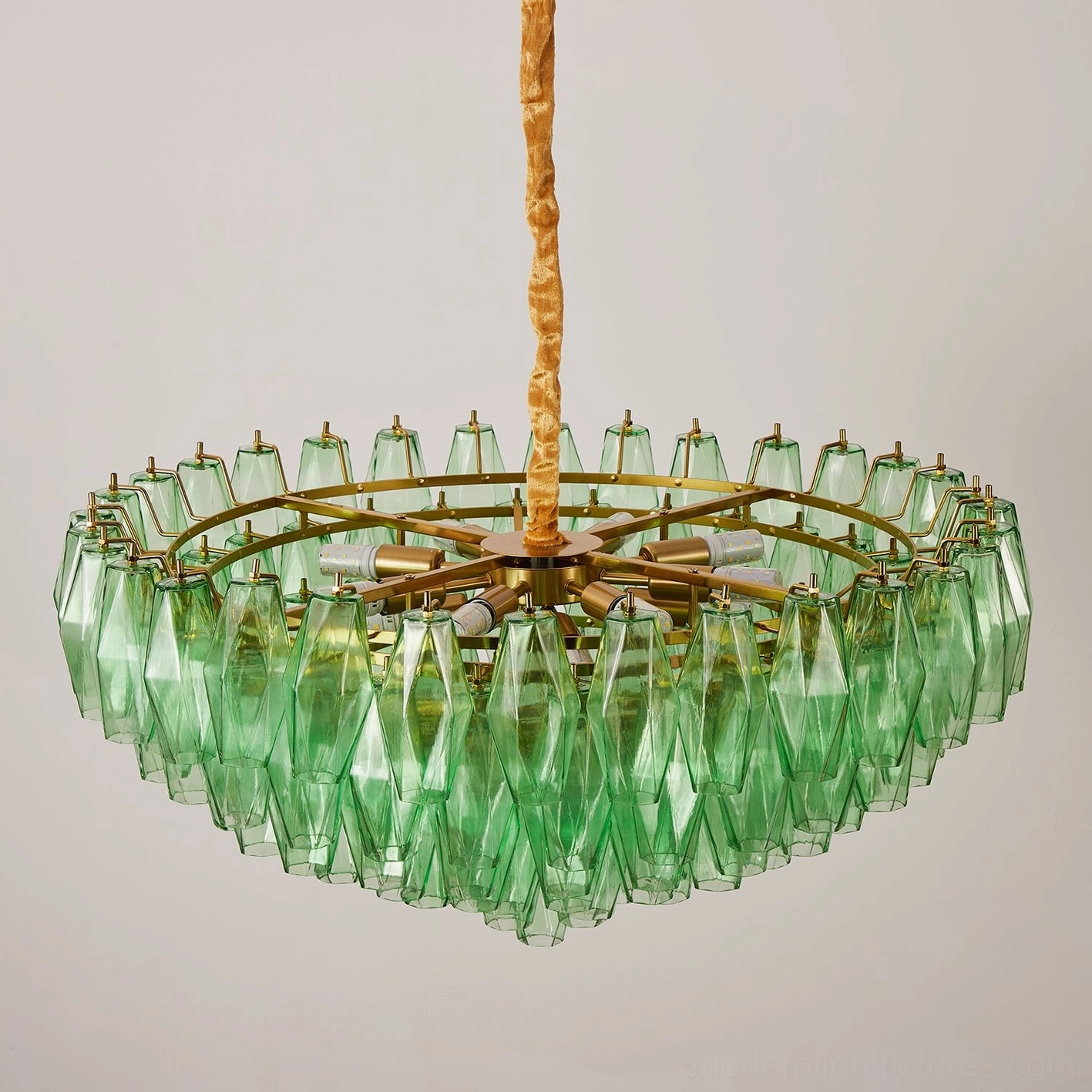 Tiered glass chandelier with velvet-wrapped suspension creating warm tactile luxury aesthetic
