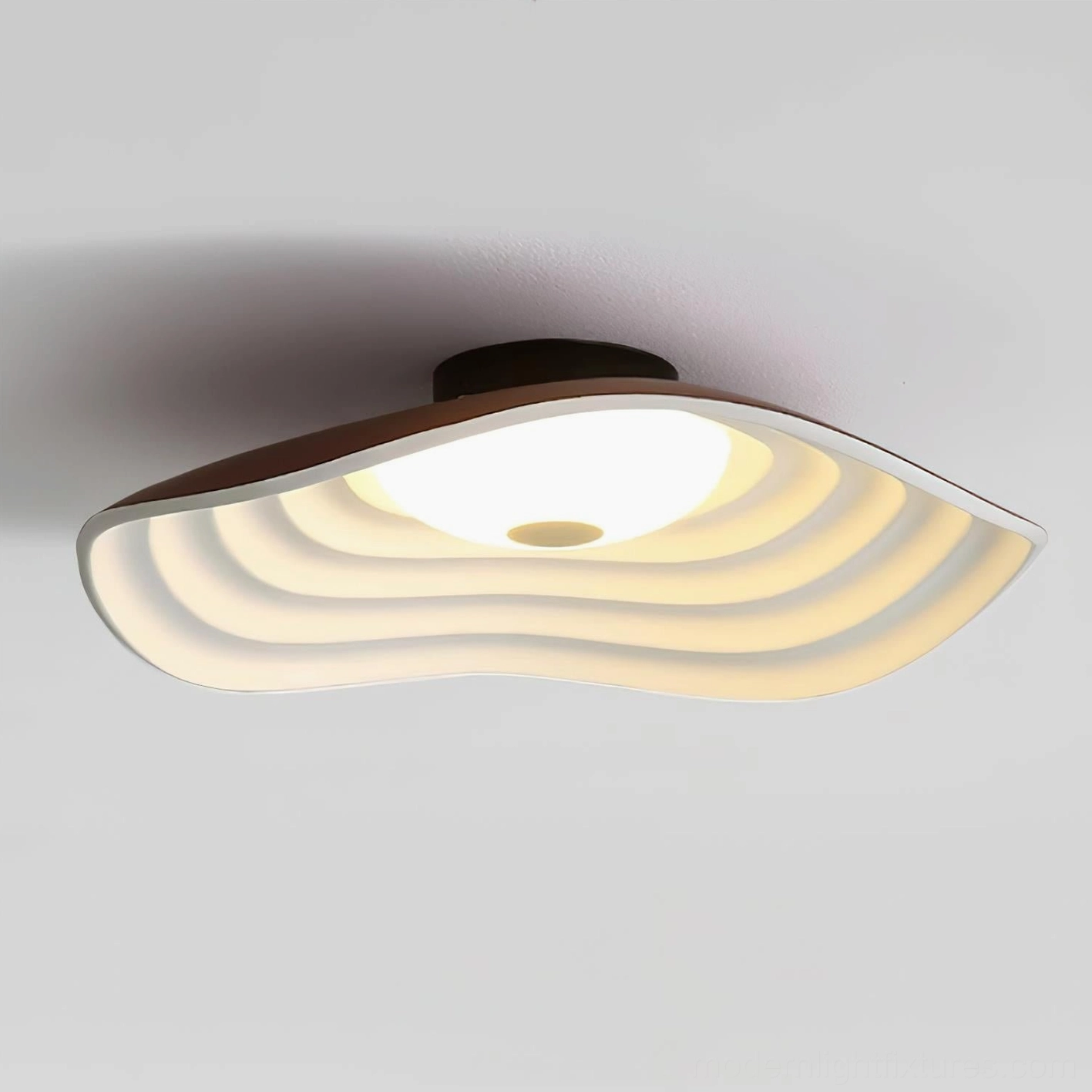 Wide Veneria wavy flush mount ceiling light close-up overhead view with brown edge trim, layered matte diffuser, and bright warm LED light