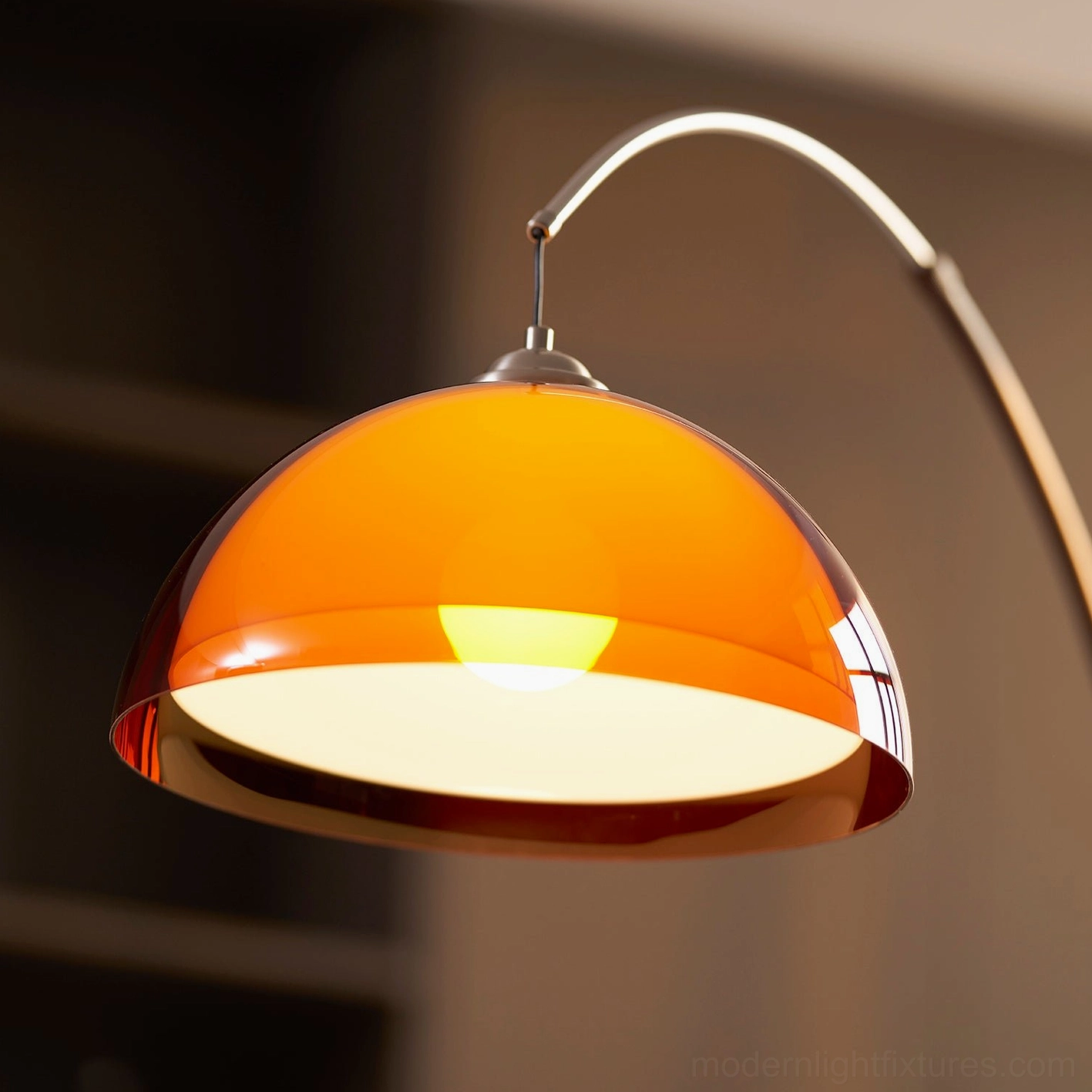 Ventoro arc floor lamp with amber shade in warm evening living room scene, cozy intimate atmosphere