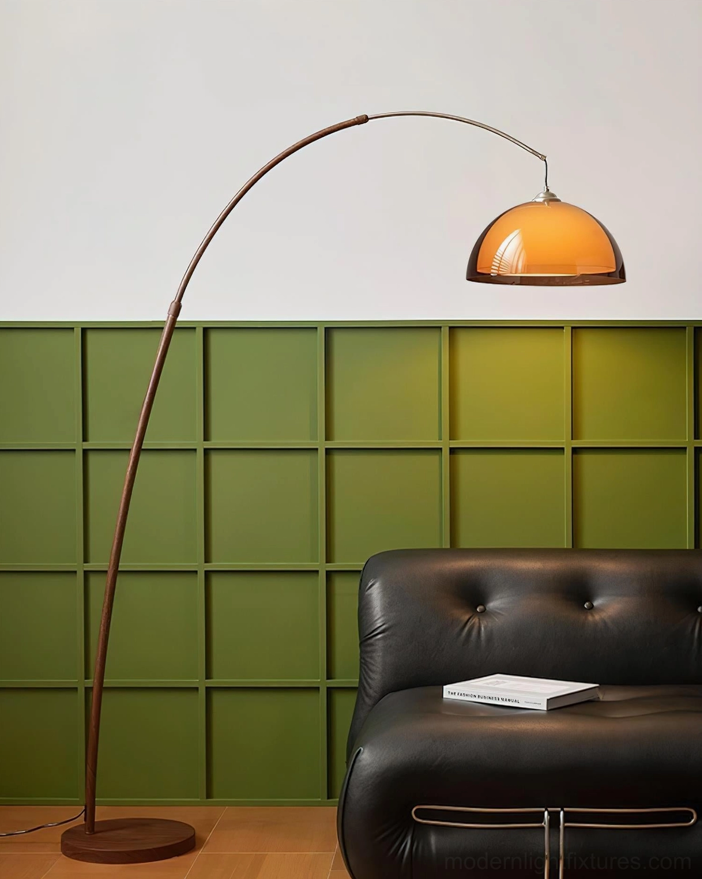 Ventoro arc floor lamp side view in modern living room with black leather sofa and green accent wall, walnut frame and amber dome