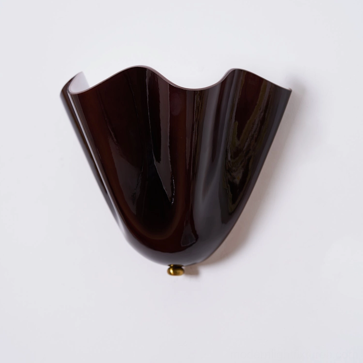 Vera amber wall sconce creating warm golden ambient light pool in intimate bedroom corner setting