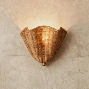 Vera rattan wall sconce angled view on textured wall - warm glowing ambient light, brass mount detail