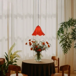 Red ruffled bell-shaped Vera glass pendant light hanging in modern dining nook at eye level