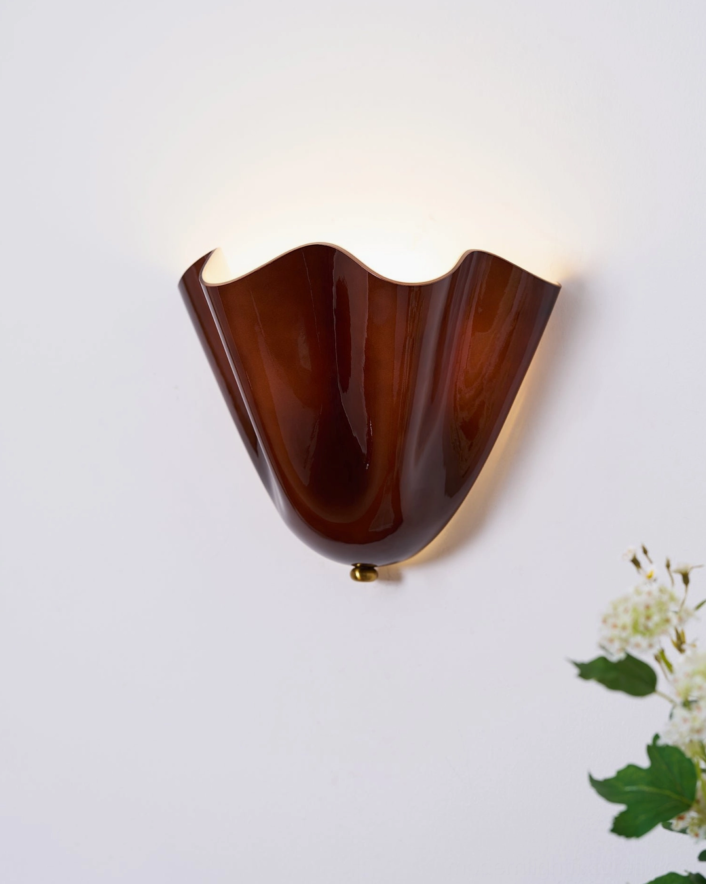 Vera wall sconce detail showing petal-curved glass form and soft warm light glow quality
