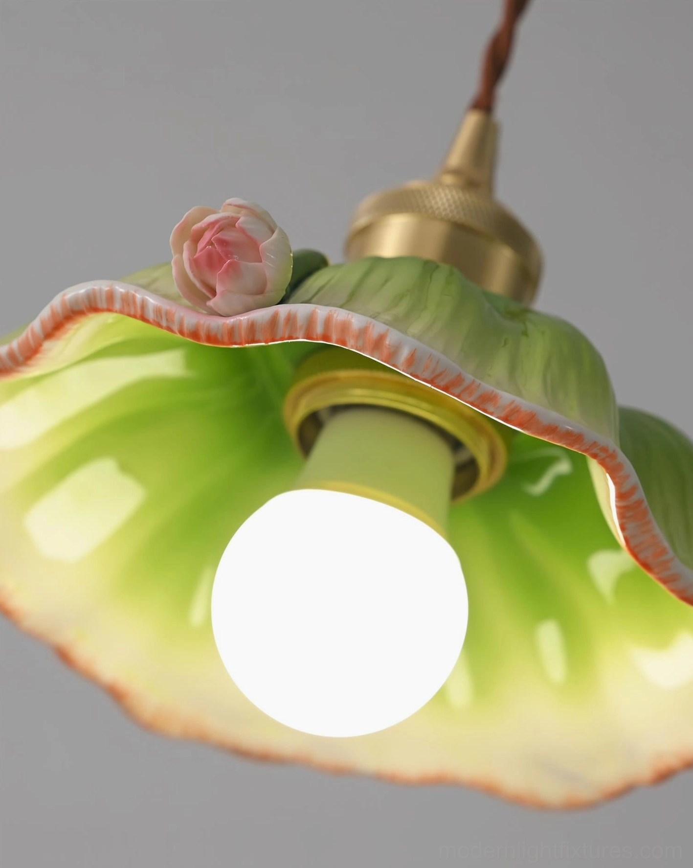 Verdant lotus pendant lamp close-up low-angle view showing detailed hand-painted ceramic petals, pink rose ornament, and glossy green interior