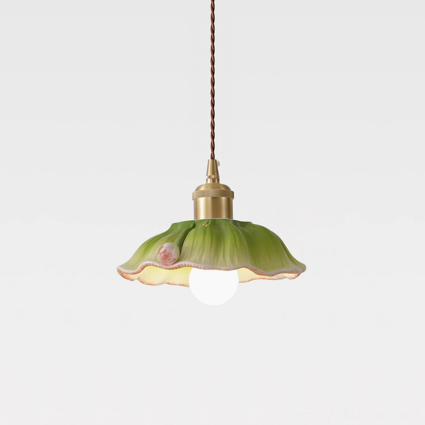 Verdant lotus pendant lamp three-quarter angle view showing glazed green ceramic petals with pink floral detail and twisted brown cord