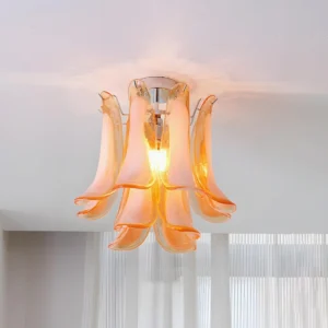 Verdelia ceiling light fixture installed upward view showing orange translucent glass petals in interior space with sheer curtains