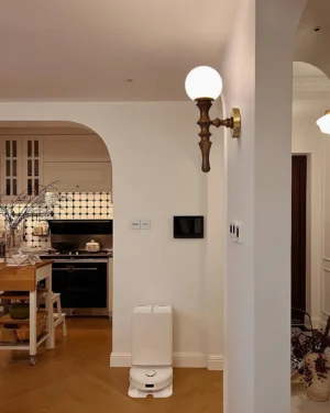 Vero wall sconce installed in modern kitchen hallway, providing warm ambient lighting with turned wood arm detail