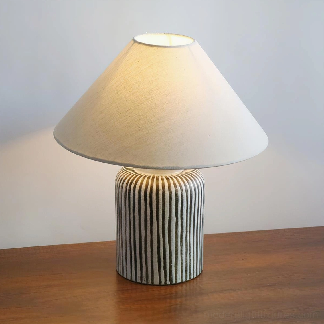 Striped ceramic table lamp displaying full silhouette with neutral fabric shade and ceramic base