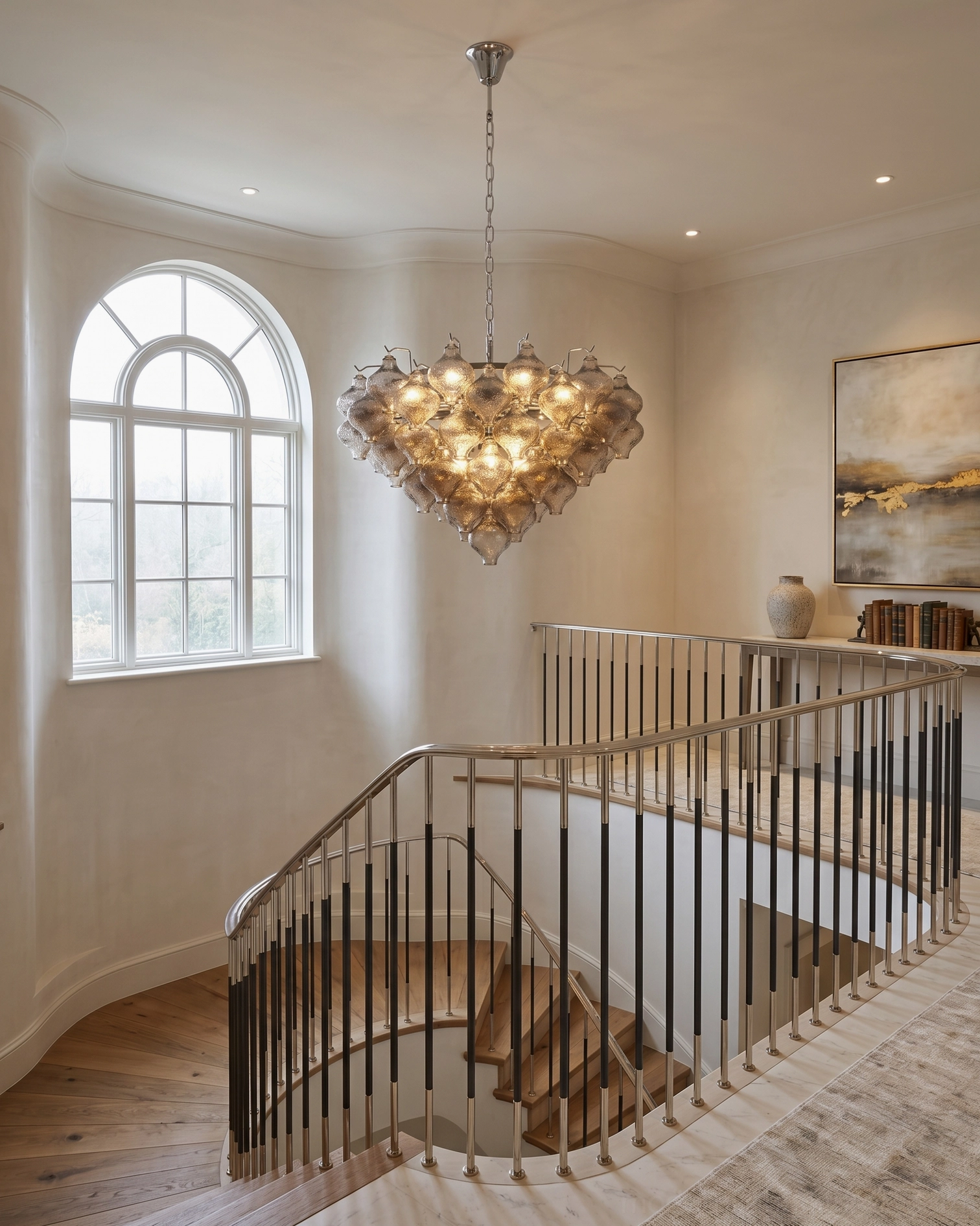 Vetrina amber tiered chandelier hanging in luxury home stairwell interior with curved arched window and warm amber glass diffusing light